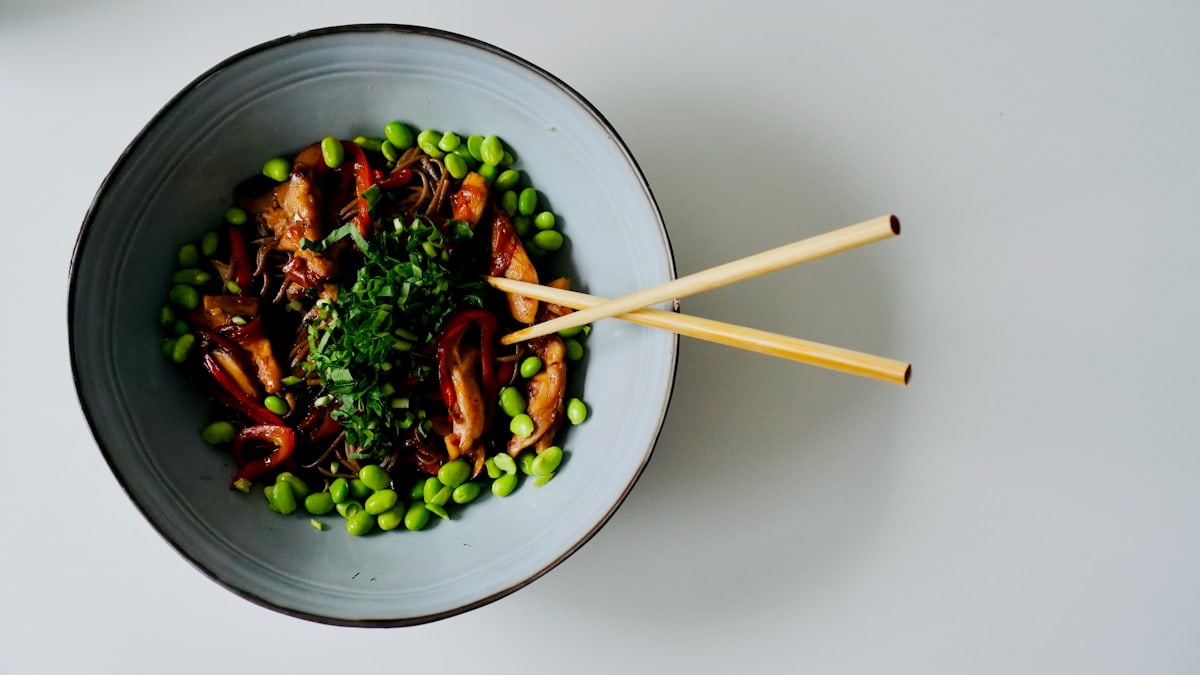a bowl of food with chopsticks in it